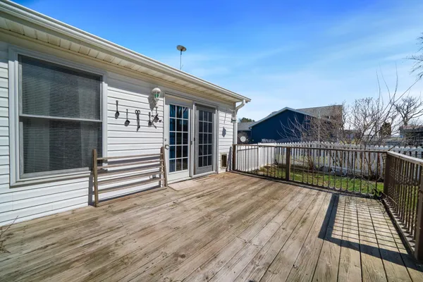 a view of backyard with small deck and wooden floor