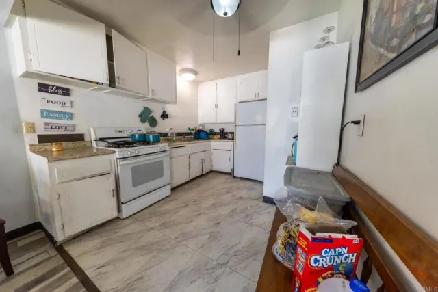 a kitchen with white cabinets and white appliances