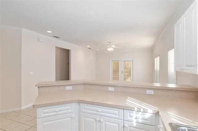 an empty room with wooden floor and fan