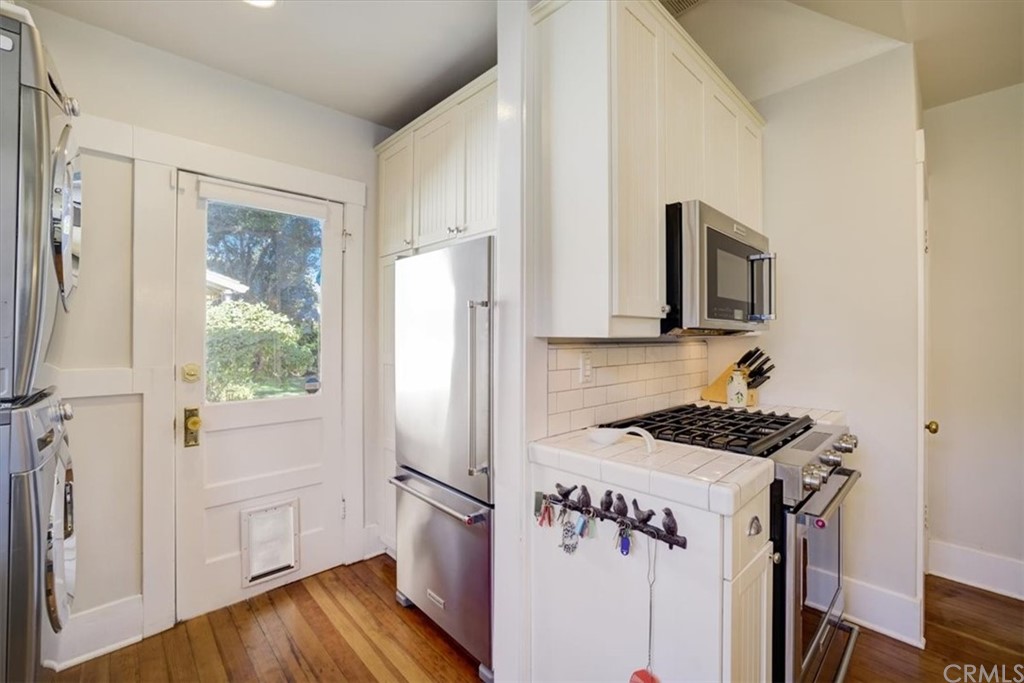 1030 Sinaloa Avenue Pasadena, CA 91104 - Photo 20 of 45 a kitchen with a refrigerator a stove a microwave and white cabinets