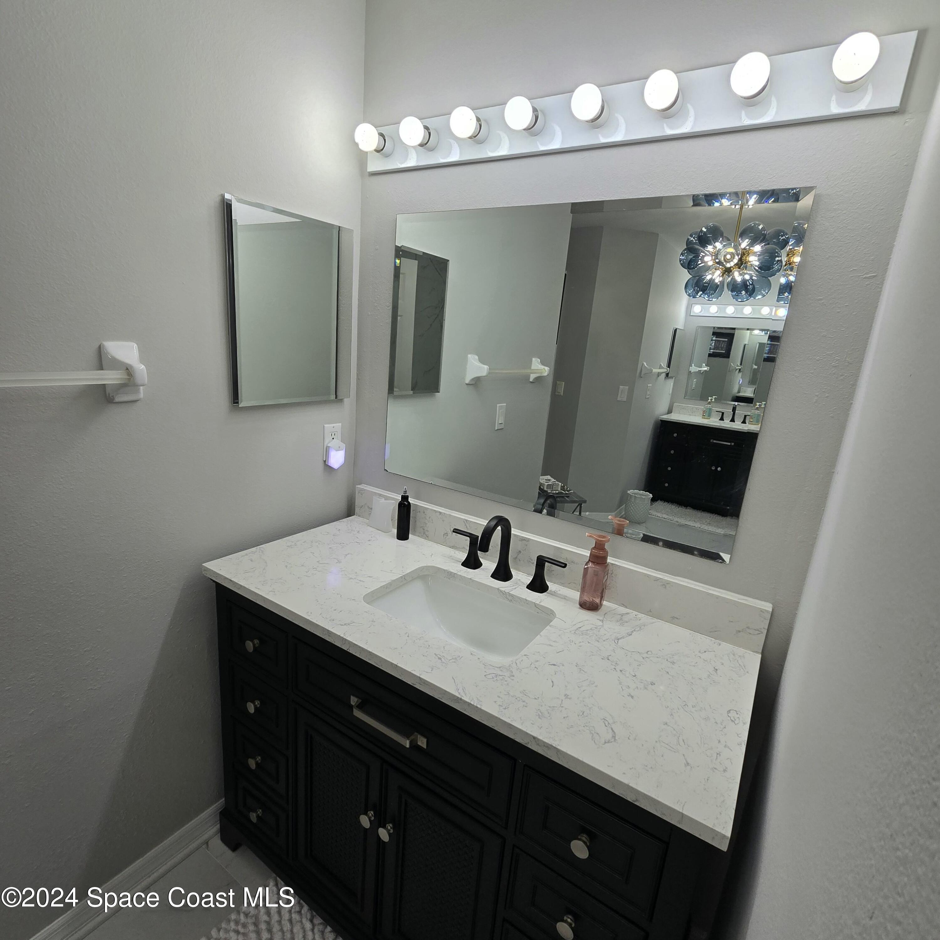 491 South Key Lime Square Southwest Vero Beach, FL 32968 - Photo 14 of 29 a bathroom with a sink vanity and mirror