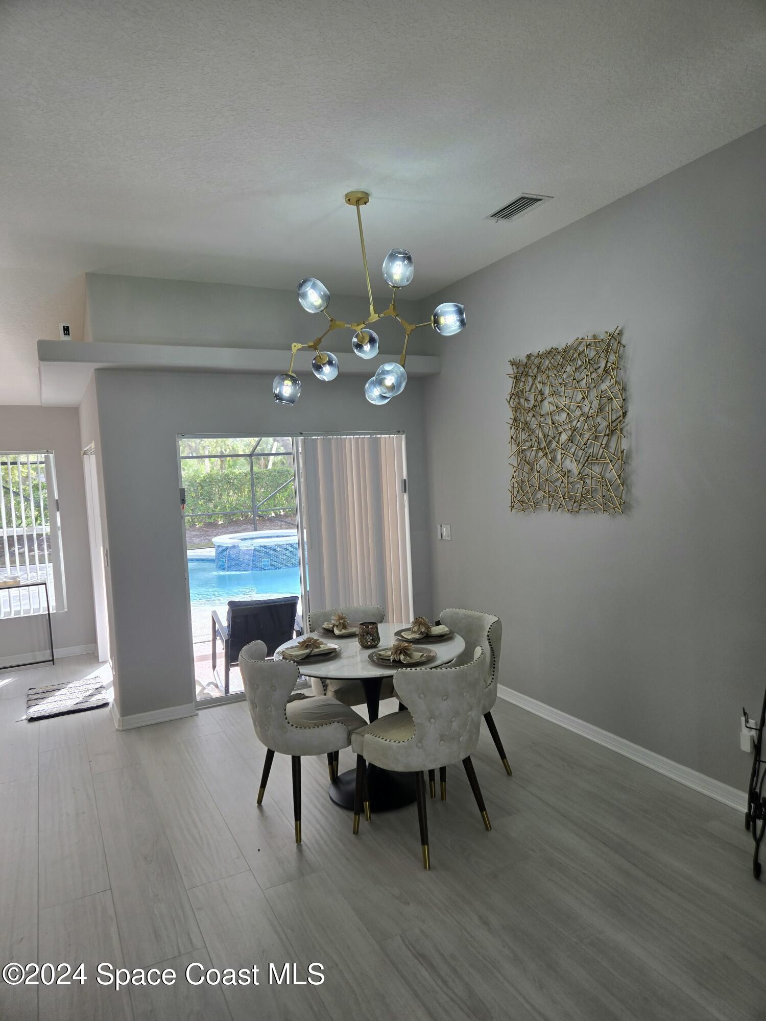 491 South Key Lime Square Southwest Vero Beach, FL 32968 - Photo 3 of 29 a view of a dining room with furniture and wooden floor