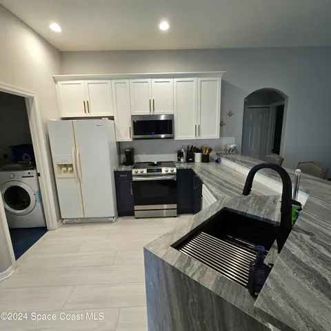 a kitchen with stainless steel appliances a stove a sink a microwave and refrigerator