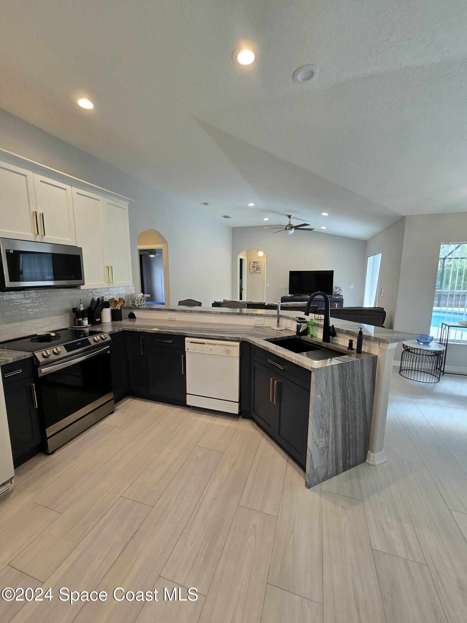 491 South Key Lime Square Southwest Vero Beach, FL 32968 - Photo 7 of 29 a large kitchen with a large counter top stainless steel appliances and cabinets