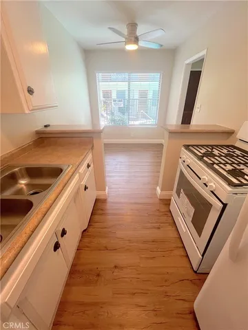 a kitchen with wooden floors and wide window