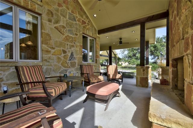 633 Trails End Road Johnson City, TX 78636 - Photo 4 of 29 A spacious covered stone patio provides a comfortable outdoor living area with a built-in fireplace.