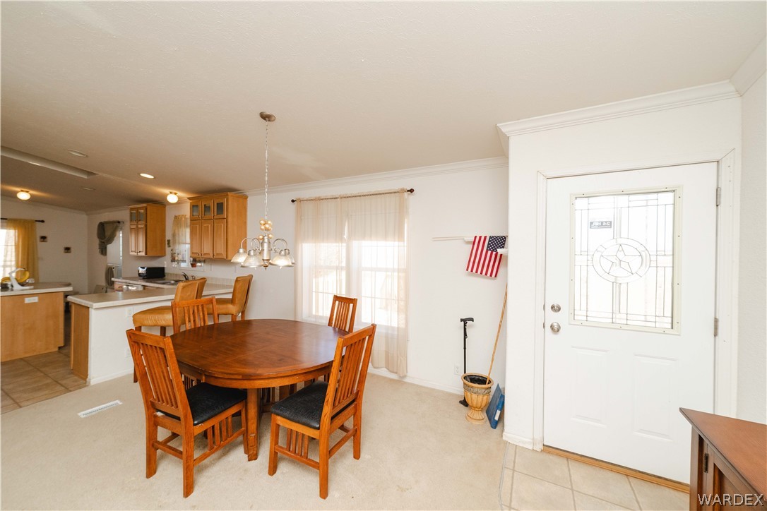 3190 East Pepper Tree Road Kingman, AZ 86409 - Photo 12 of 67 a dining room with furniture and a chandelier