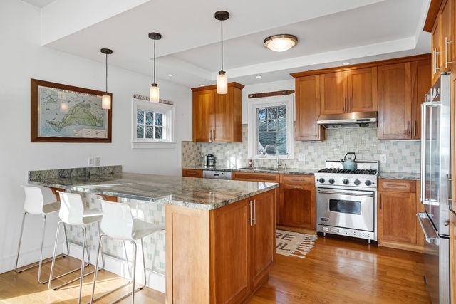a kitchen with stainless steel appliances granite countertop a stove a sink and a refrigerator