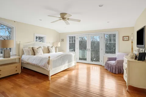 a spacious bedroom with a large bed and a flat tv screen