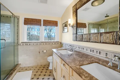 a bathroom with a granite countertop sink and a shower