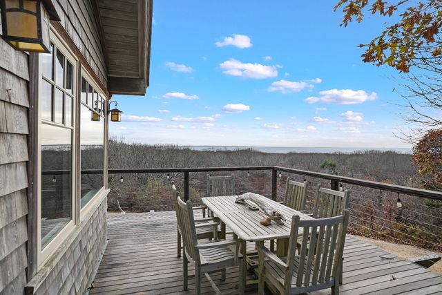 a view of a balcony with wooden floor and iron fence