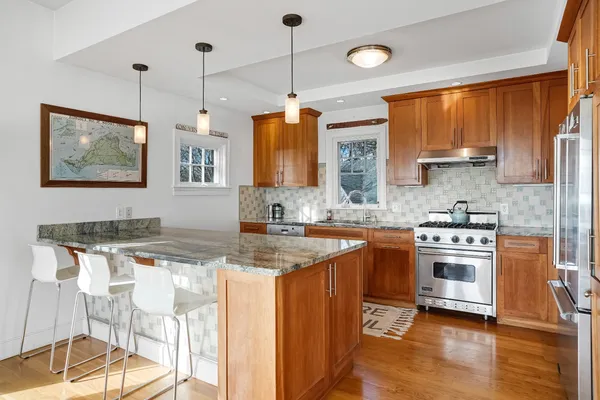 a kitchen with stainless steel appliances granite countertop a stove a sink and a refrigerator