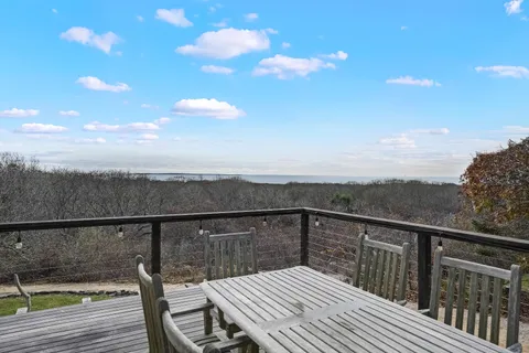 a view of a balcony with wooden floor and fence