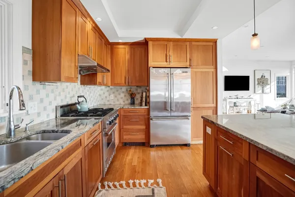 a kitchen with stainless steel appliances granite countertop a sink stove and refrigerator