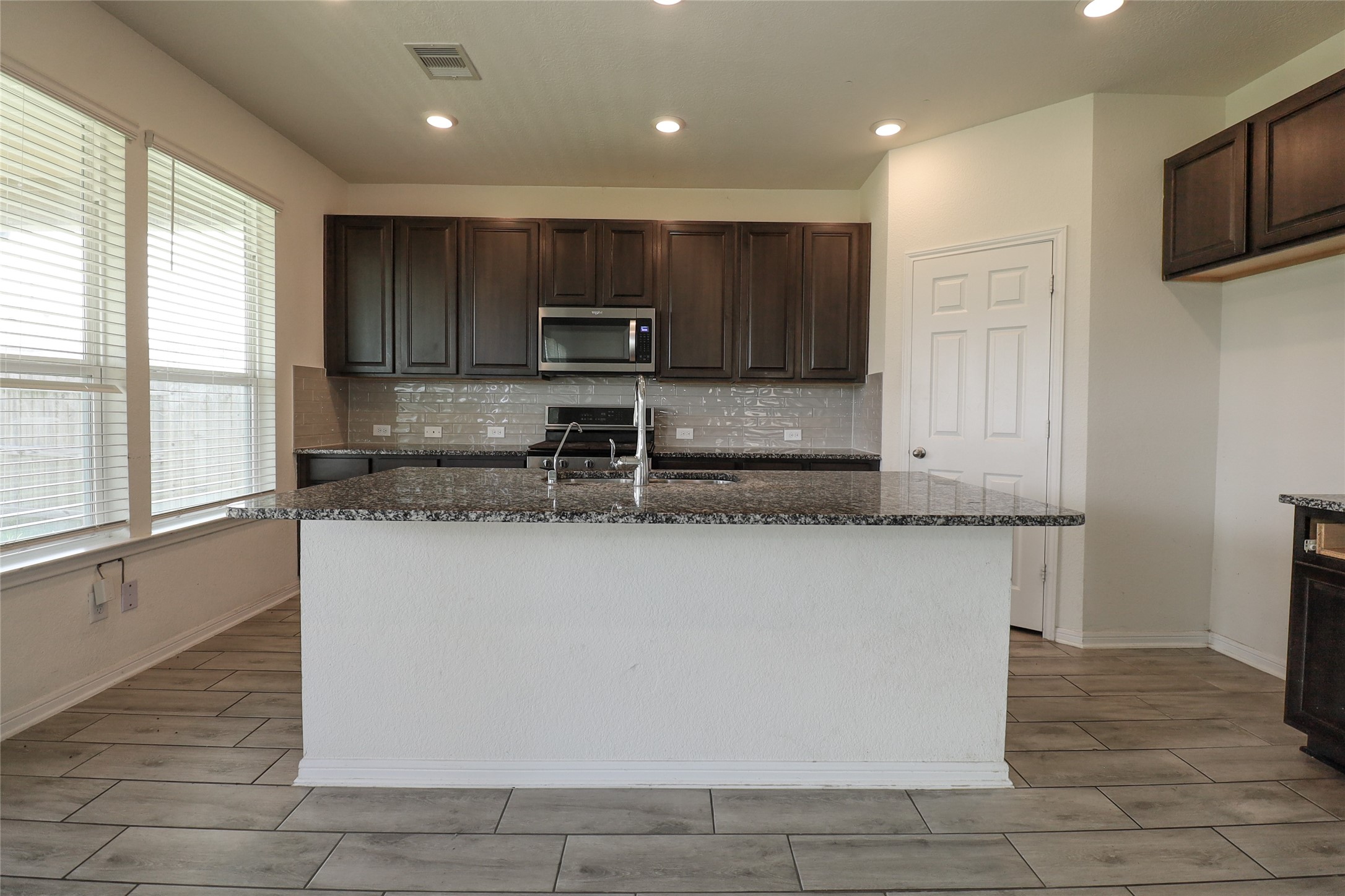 1418 Red Hills Drive Rosharon, TX 77583 - Photo 11 of 36 a kitchen with kitchen island granite countertop a stove top oven a sink a counter space and cabinets