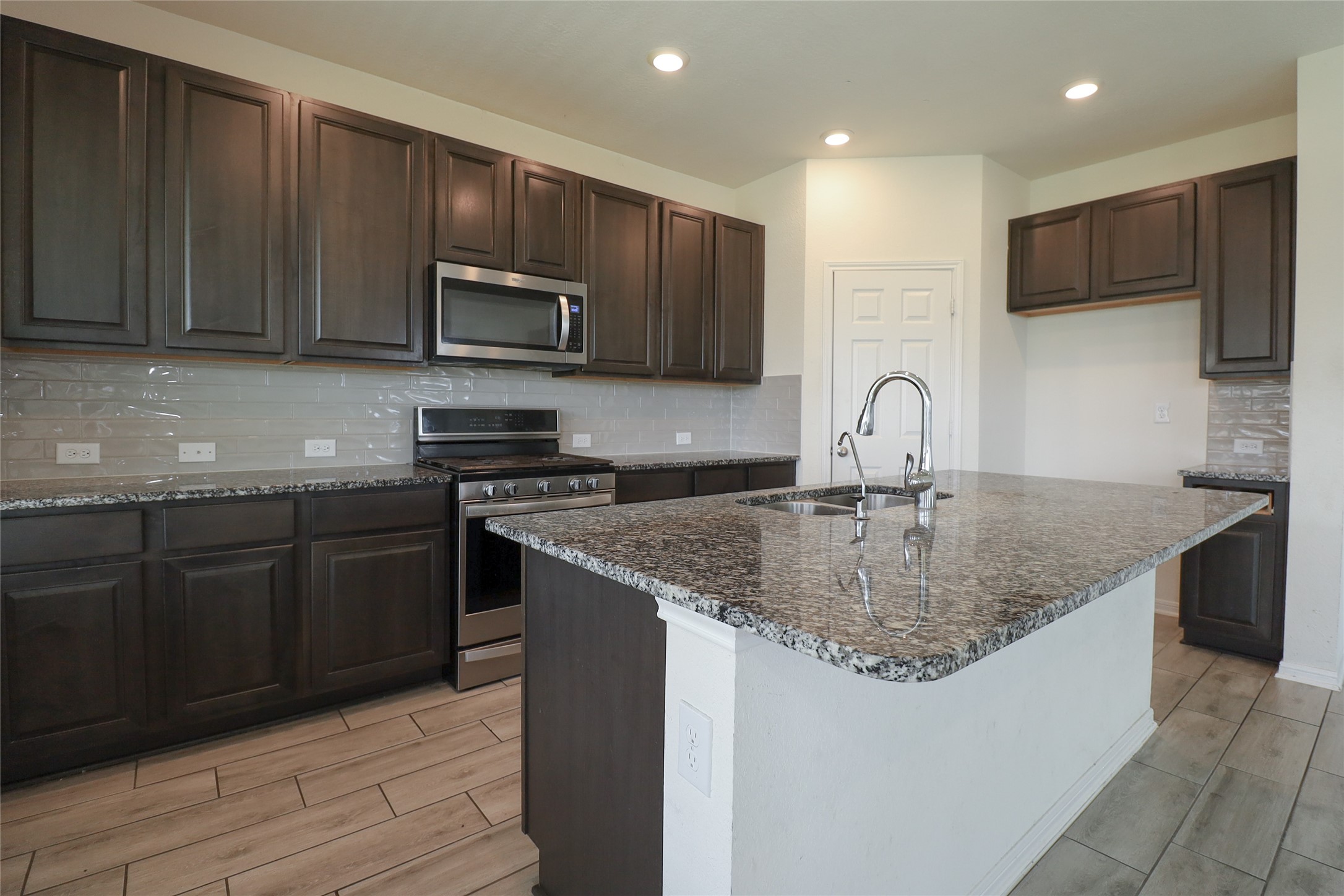 1418 Red Hills Drive Rosharon, TX 77583 - Photo 14 of 36 a kitchen with stainless steel appliances granite countertop a sink stove microwave and refrigerator