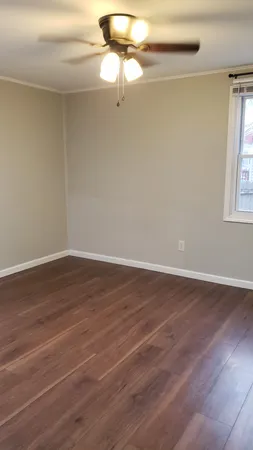 a view of a room with wooden floor and fan