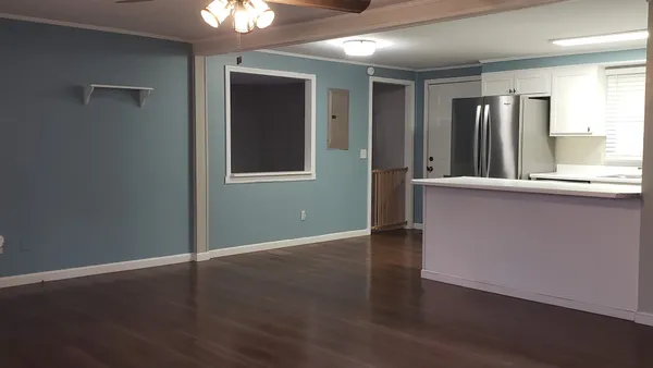 an empty room with wooden floor and windows