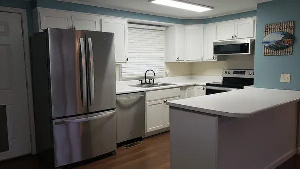 a kitchen with stainless steel appliances a refrigerator stove microwave and sink