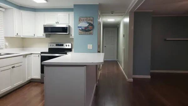 a kitchen with a sink a microwave and cabinets