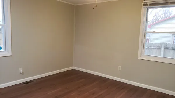 a view of a small space with wooden floor and a window