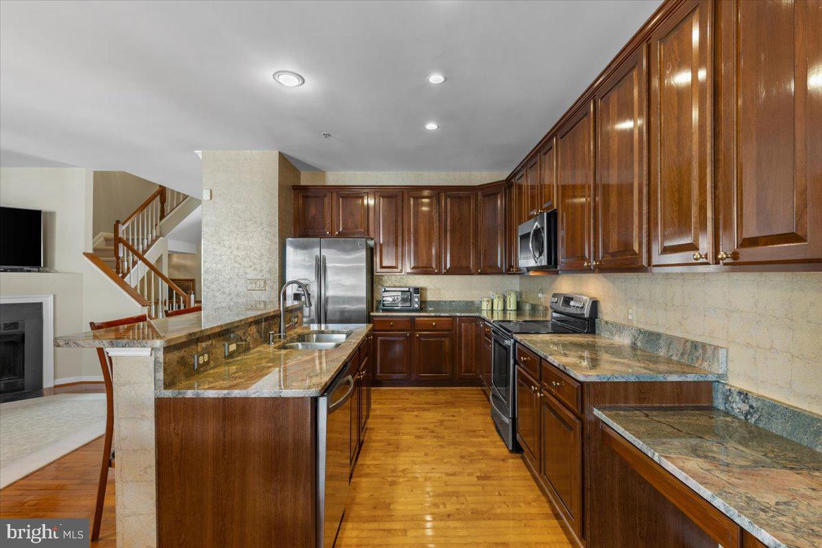 46134 Brisbane Square Sterling, VA 20165 - Photo 16 of 48 a kitchen with kitchen island granite countertop a sink a counter top space appliances and cabinets
