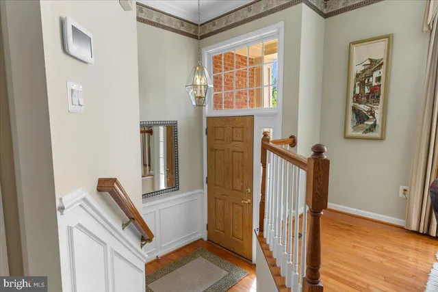 a kitchen with stainless steel appliances granite countertop a stove top oven a sink dishwasher a dining table and chairs with wooden floor