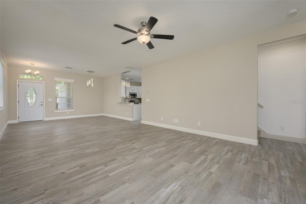 6227 Blue Runner Court Lakewood Ranch, FL 34202 - Photo 13 of 46 an empty room with wooden floor and a ceiling fan