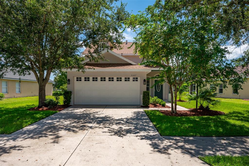 6227 Blue Runner Court Lakewood Ranch, FL 34202 - Photo 2 of 46 a front view of a house with a yard and trees