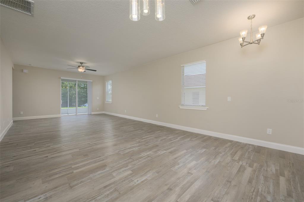 6227 Blue Runner Court Lakewood Ranch, FL 34202 - Photo 10 of 46 wooden floor in an empty room with a window
