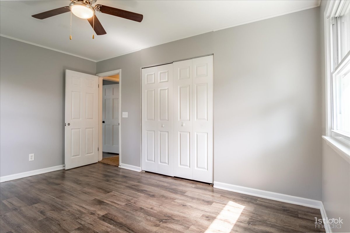 53 Marnel Road Montgomery, IL 60538 - Photo 23 of 33 an empty room with wooden floor ceiling fan and windows