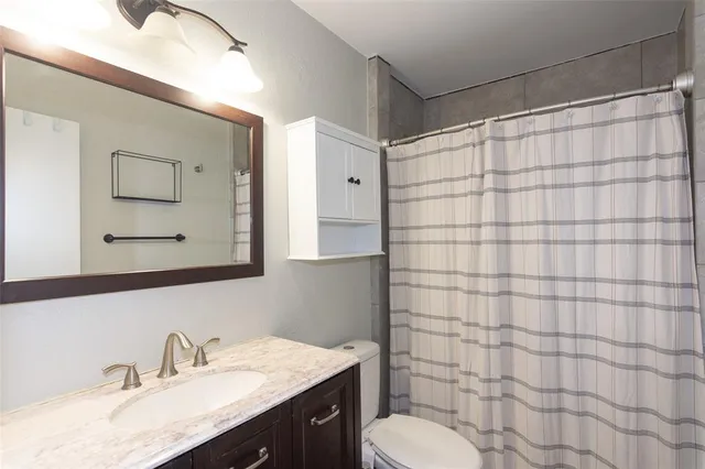 a bedroom with a large bed and a ceiling fan