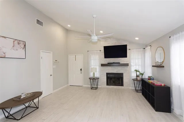 a living room with furniture a fireplace and a flat screen tv