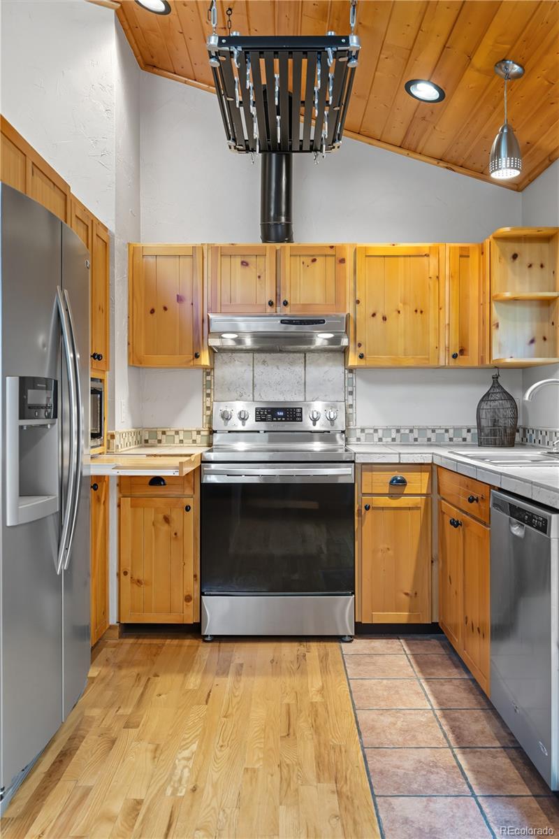 401 Lake Road Idaho Springs, CO 80452 - Photo 13 of 47 a kitchen with stainless steel appliances granite countertop a sink a stove and a refrigerator