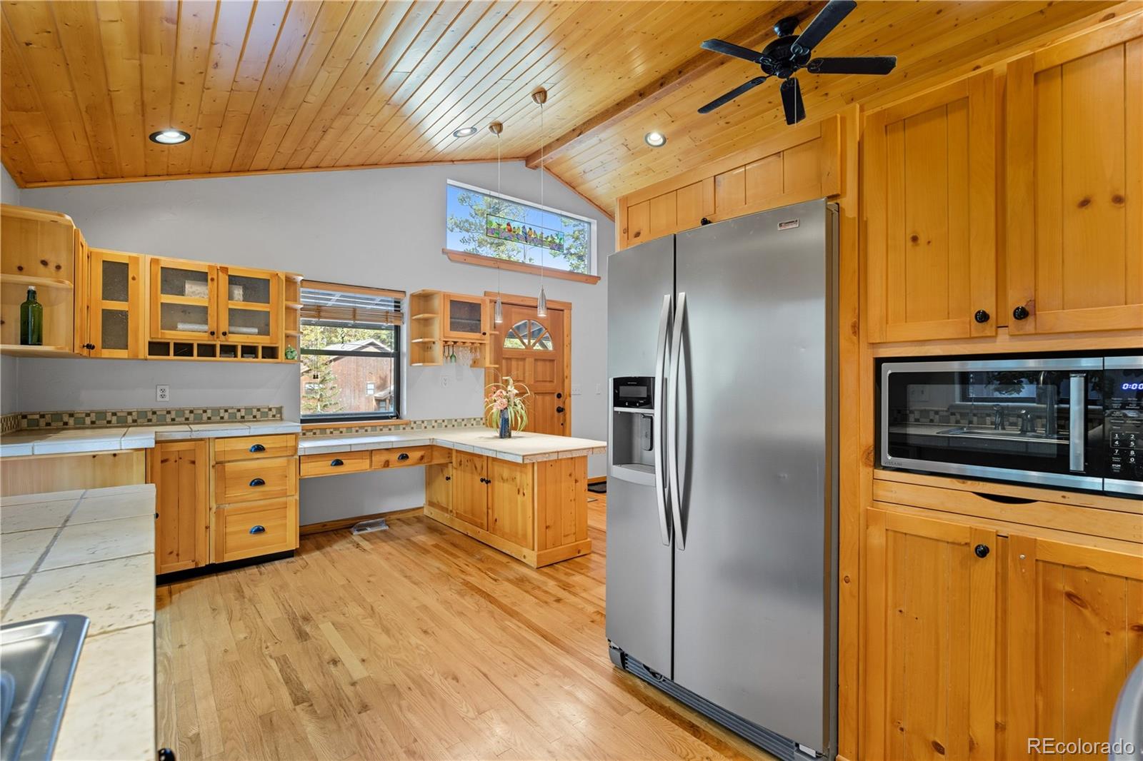 401 Lake Road Idaho Springs, CO 80452 - Photo 5 of 47 a kitchen with stainless steel appliances granite countertop a refrigerator a oven and white cabinets with wooden floors