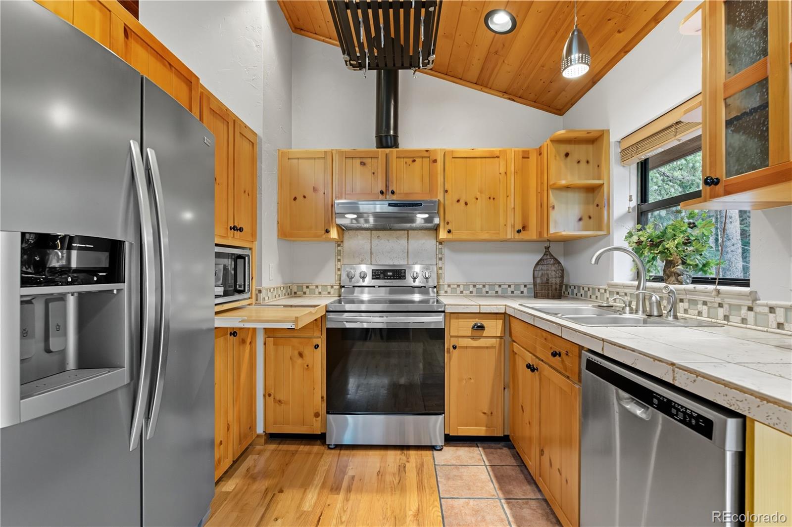 401 Lake Road Idaho Springs, CO 80452 - Photo 9 of 47 a kitchen with stainless steel appliances granite countertop a stove a sink and a refrigerator