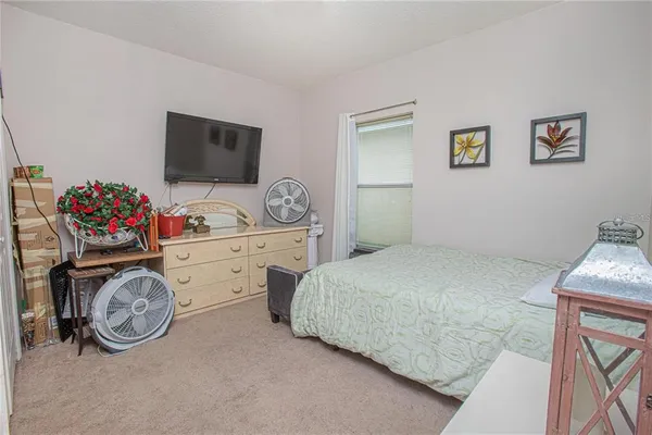 a bedroom with a bed and a tv on the dresser