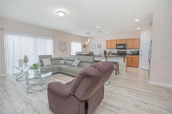 a living room with stainless steel appliances furniture and wooden floor