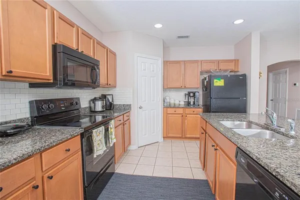 a kitchen with stainless steel appliances granite countertop a sink stove and cabinets