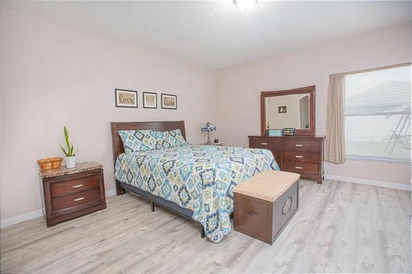 a bedroom with a large bed and a chandelier