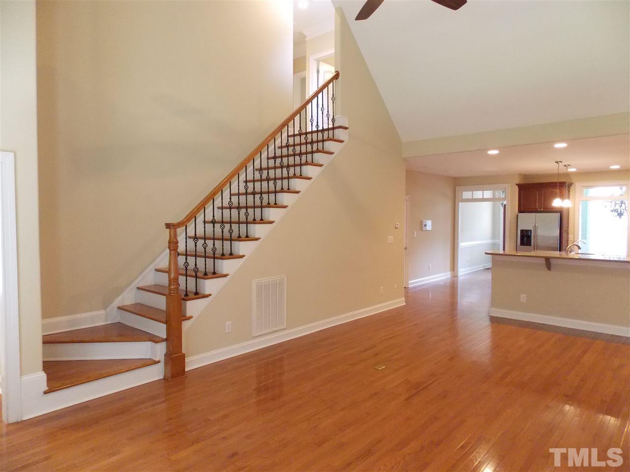 12233 Beestone Lane Raleigh, NC 27614 - Photo 9 of 25 a view of a hallway with wooden floor and staircase