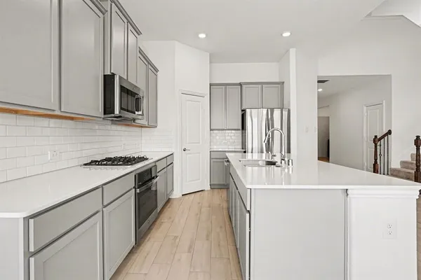 a kitchen with stainless steel appliances a sink stove and refrigerator