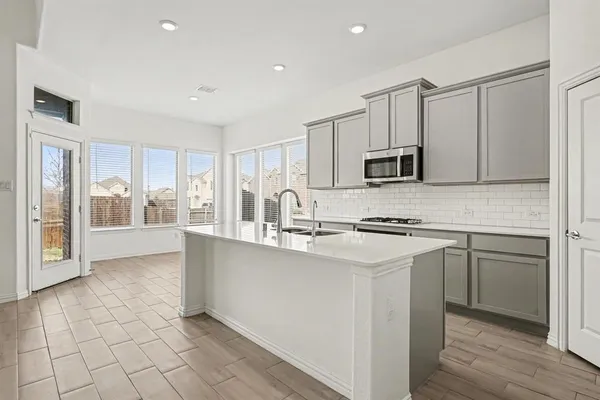 a kitchen with stainless steel appliances granite countertop a stove a sink and a refrigerator