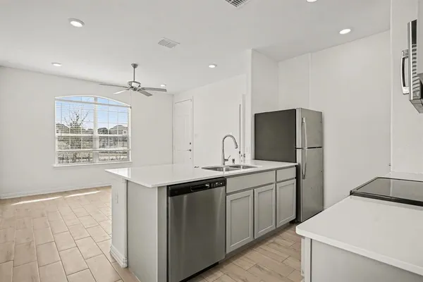 a kitchen with a sink a refrigerator and window