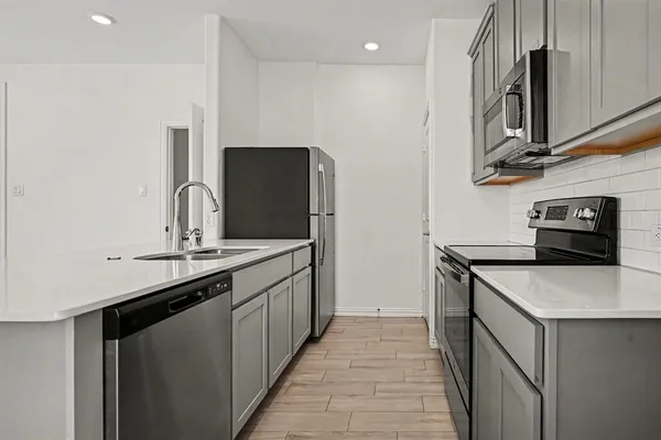 a kitchen with stainless steel appliances granite countertop a sink stove and refrigerator