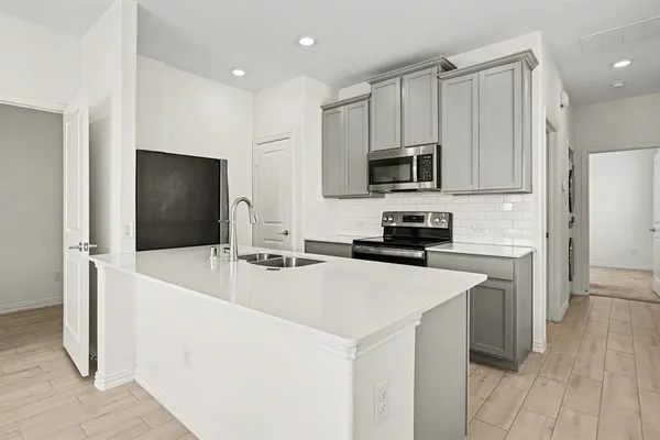 a kitchen with stainless steel appliances a refrigerator sink and microwave