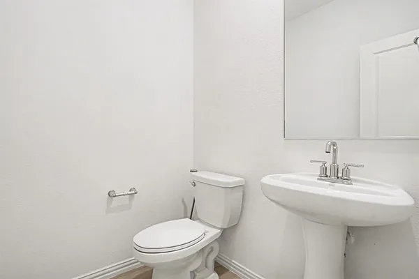 a bathroom with a sink a toilet and mirror