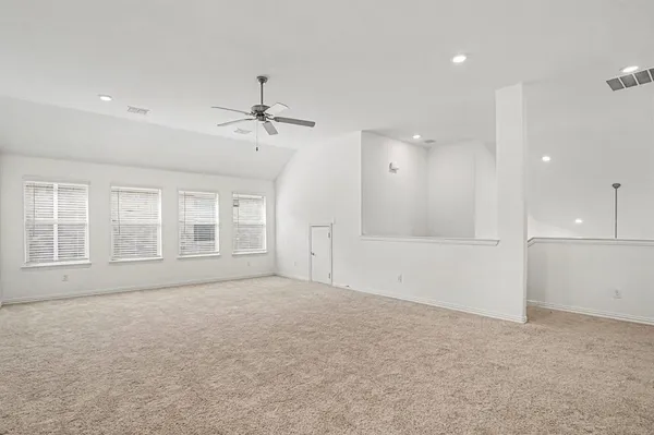 an empty room with fan and windows