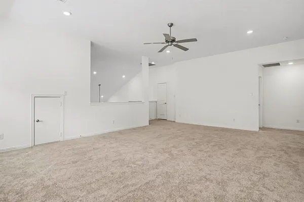 an empty room with fan and windows