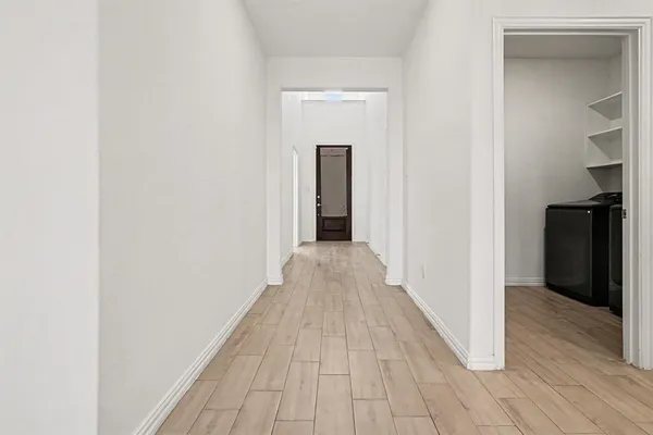 a view of a hallway with wooden floor and closet